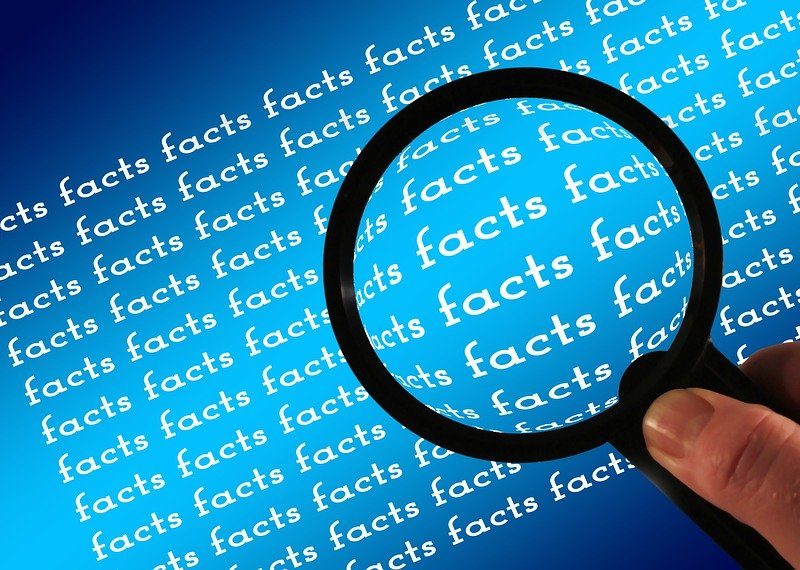 Vergrößerungsglas über Schriftzug "facts"