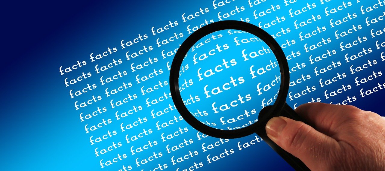 Vergrößerungsglas über Schriftzug "facts"