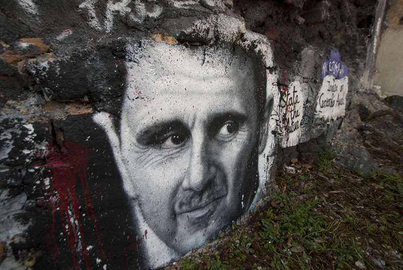 Bild von Assad auf Kriegstrümmern