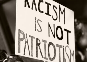 Protestschild "Racism is not Patriotism"