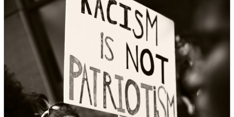 Protestschild "Racism is not Patriotism"