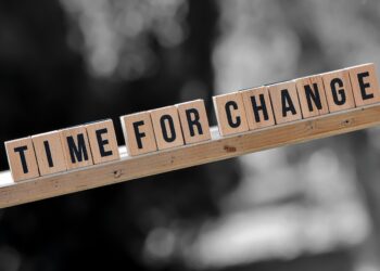 Scrabble-Buchstaben "TIME FOR CHANGE" auf Holzleiste