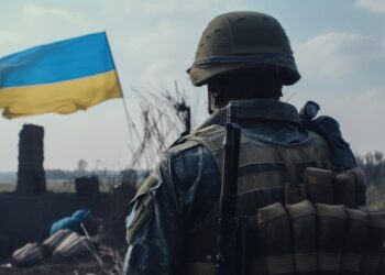 Ukrainischer Soldat vor Landesflagge