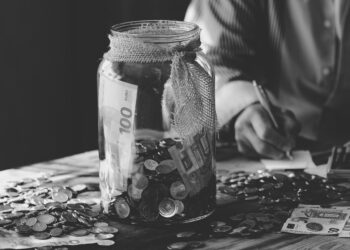 Geld im Glas und auf einem Tisch, Symbolbild für Etat und Sparen