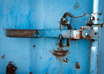 Verrosteter Griff an blauen Container