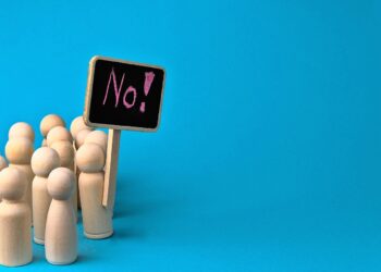 Holzfiguren mit Schild "No!"