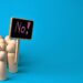 Holzfiguren mit Schild "No!"