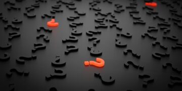 Lauter schwarze Fragezeichen mit drei roten Fragezeichen