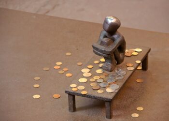 Miniatur Bronze-Figur auf Tisch umgeben von Kleingeld