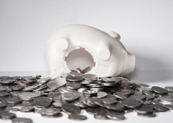 Geöffnetes Sparschwein mit davor liegenden Geldmünzen