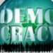 Schriftzug "Democracy" auf Weltkugel mit Menschenmenge davor als Schattenriß