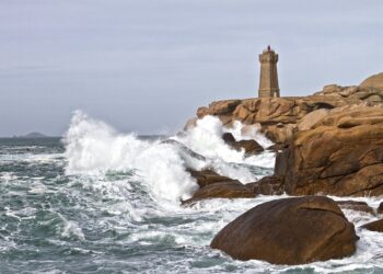 Felsen und Leuchtturm in der Brandung