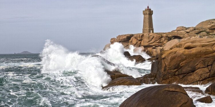 Felsen und Leuchtturm in der Brandung