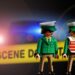 3 Polizisten (Playmobil) vor gelben Absperrband mit Aufschrift "Crime Scene"