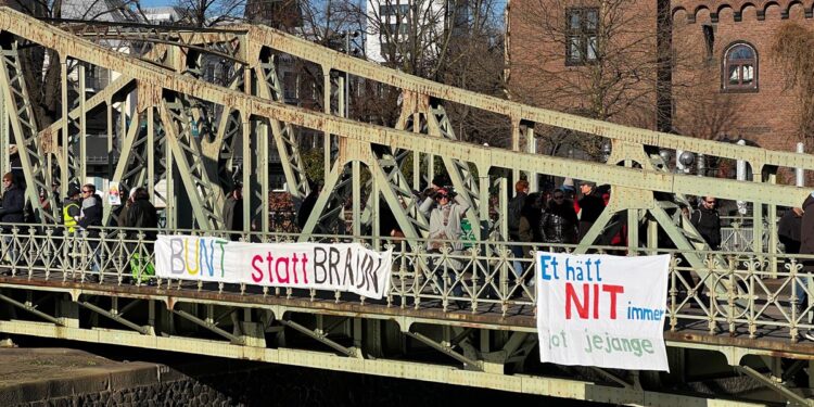 Brücke mit Banner "Bunt statt braun" und weiteren kölschen Spruch