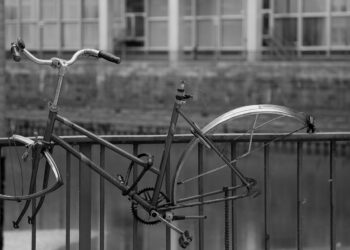 Angekettetes altes Fahrrad, bei dem Räder und Sattel gestohlen wurden