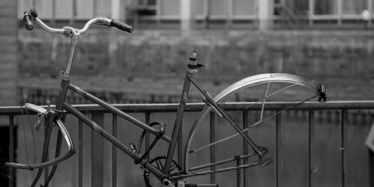 Angekettetes altes Fahrrad, bei dem Räder und Sattel gestohlen wurden