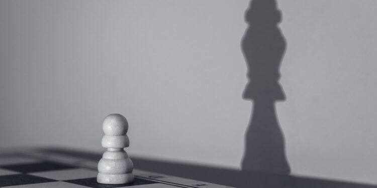 Schachbrett mit Bauer, der den Schatten wirft eines Königs