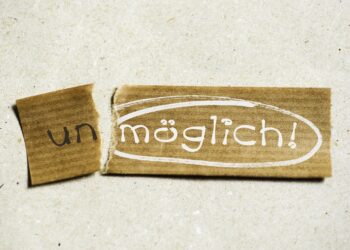 Vom Schild "unmöglich" bricht ein Stück ab und wird zu "möglich"