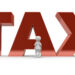 Vor einem riesigen Schriftzug in 3D "TAX" steht eine kleine weiße Figur