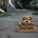 Teddy Bär auf eiern Straße mit einem Schild "stop war"