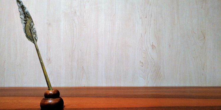 Schreibfeder in einem Halter auf einer Tischplatte