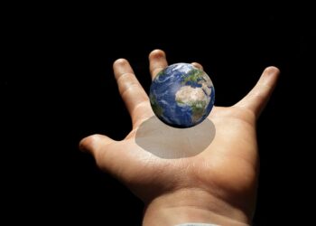 Kleine Weltkugel über einer ausgestreckten Kinderhand