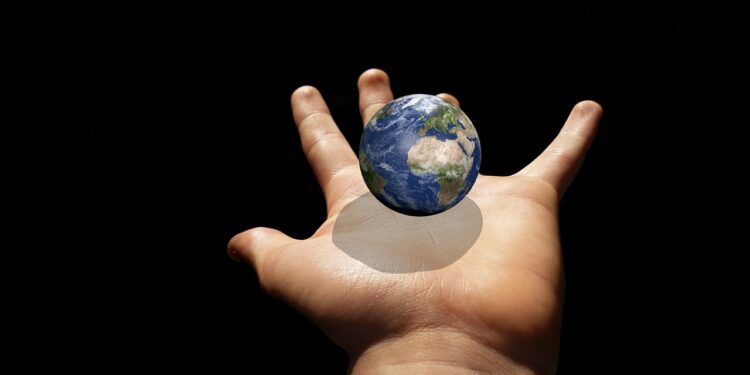 Kleine Weltkugel über einer ausgestreckten Kinderhand