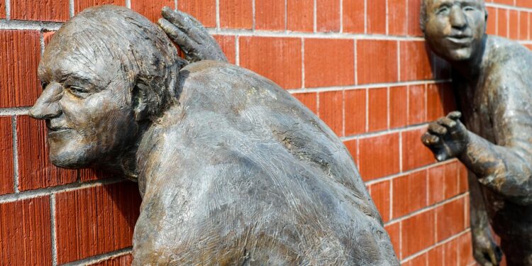 Skulptur. zwei alte horchen an einer roten Ziegelwand