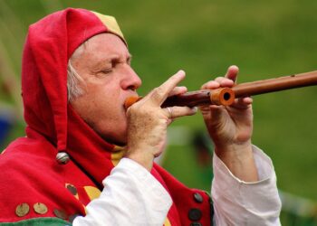 Mann mit Narrenkappe und Flöte, ähnlich der Figur des "Rattenfängers von Hameln"