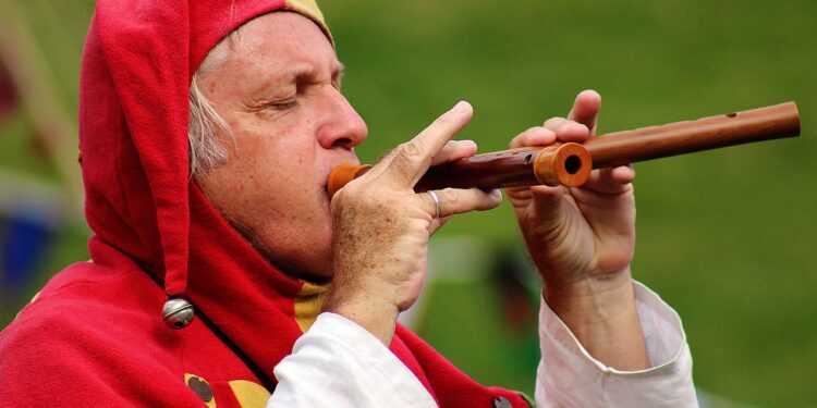 Mann mit Narrenkappe und Flöte, ähnlich der Figur des "Rattenfängers von Hameln"