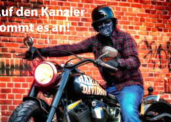 Rocker auf Harley Davidson vor Mauer mit der Aufschrift "Auf den Kanzler kommt es an!"
