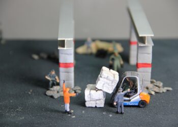 Handwerker an einem Bauprojekt als Miniaturfiguren