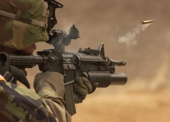 US-Amerikanischer Soldat mit automatischem Gewehr zielt und schießt