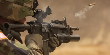 US-Amerikanischer Soldat mit automatischem Gewehr zielt und schießt