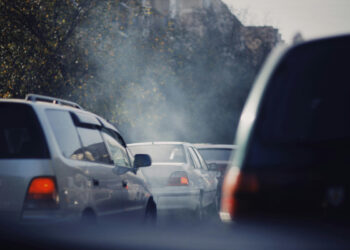 Aus dem Auspuff qualmende Autos im Stau