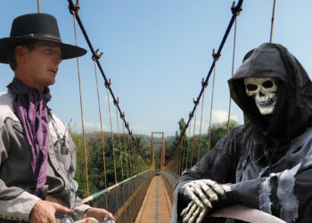 Ein Coboy und ein Sensenmann verhandeln auf einer Brücke