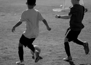 Kinder spielen Fußball auf der Strasse