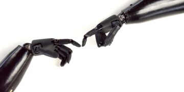 Zwei Roboterfinger berühren sich, analog zum weltberühmten Gemälde "die Schöpfung" von Michelangelo