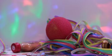 Karnevalsartikel wie rote Nase und Luftschlangen liegen nach der Party auf dem Boden