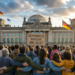 Menschenmenge vor dem Bundestag mit einem Plakat "Demokratie braucht uns alle". KI generiert mit ChatGPT