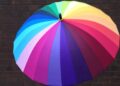 Regenschirm in Regenborgenfarben als Symbol frü den Schutz von Menschen mit Migrationsintergrund gegen Hate, Gewalt und Vertreibungsphantasien von AfD und anderen Nazis oder Rechtsextremisten.