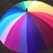 Regenschirm in Regenborgenfarben als Symbol frü den Schutz von Menschen mit Migrationsintergrund gegen Hate, Gewalt und Vertreibungsphantasien von AfD und anderen Nazis oder Rechtsextremisten.